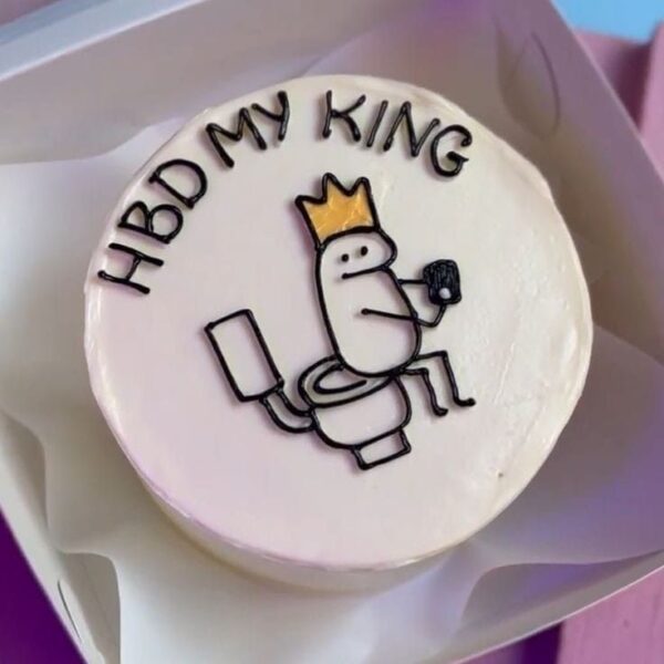 Mini bolo divertido com a frase “HBD My King” e ilustração humorística.