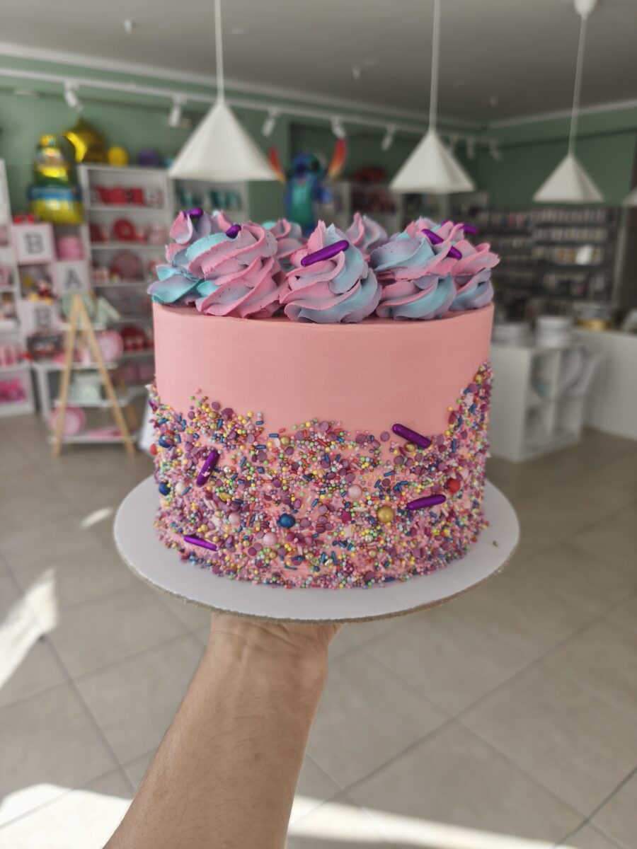 Bolo colorido com buttercream rosa e sprinkles coloridos em estilo Candy Party.
