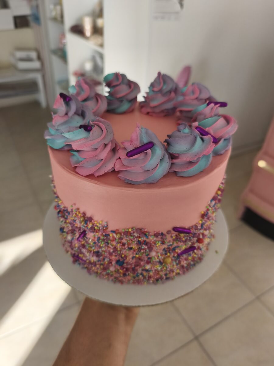 Bolo colorido com buttercream rosa e sprinkles coloridos em estilo Candy Party.