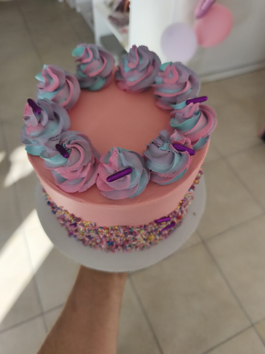 Bolo colorido com buttercream rosa e sprinkles coloridos em estilo Candy Party.