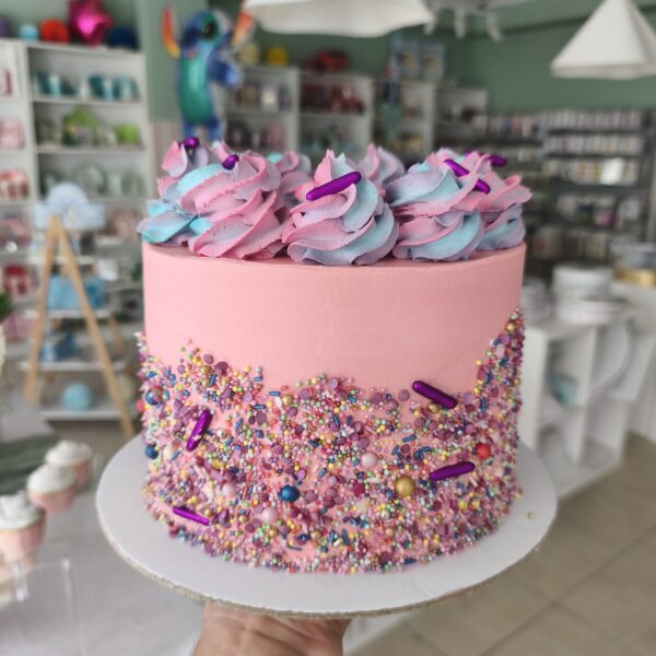 Bolo colorido com buttercream rosa e sprinkles coloridos em estilo Candy Party.