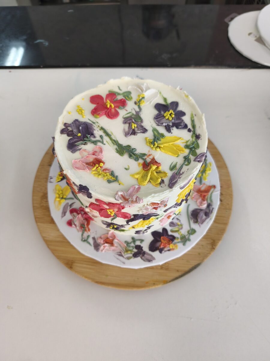 Bolo floral pintado à mão com buttercream colorido em tons vibrantes.