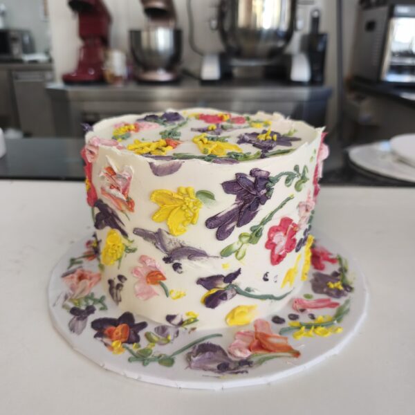 Bolo floral pintado à mão com buttercream colorido em tons vibrantes.