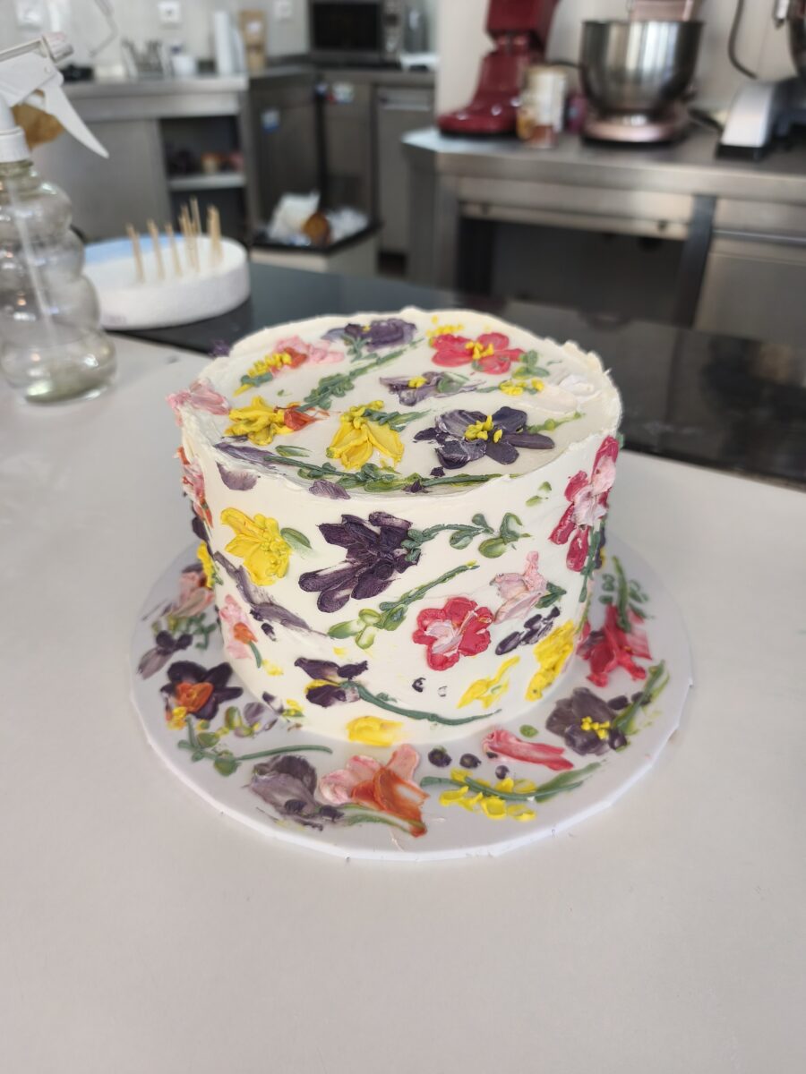 Bolo floral pintado à mão com buttercream colorido em tons vibrantes.