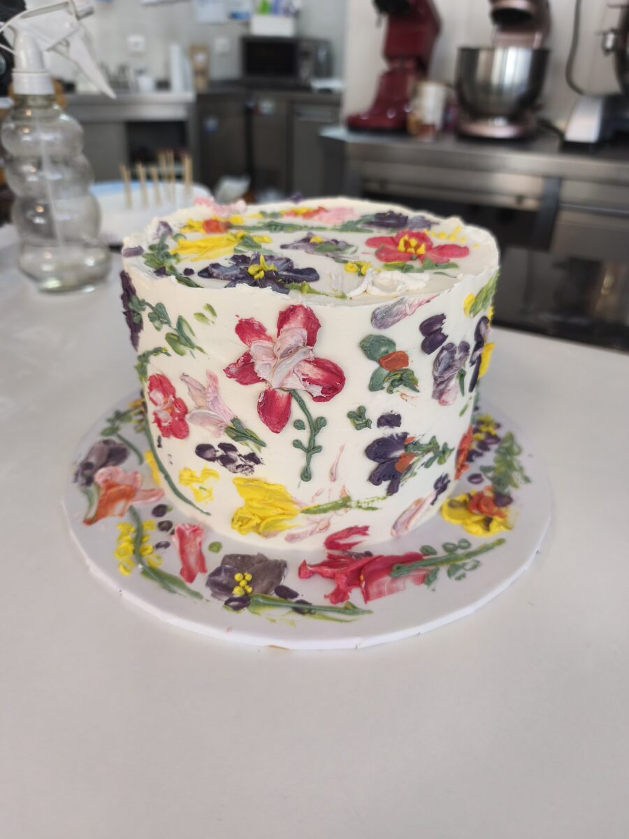 Bolo floral pintado à mão com buttercream colorido em tons vibrantes.