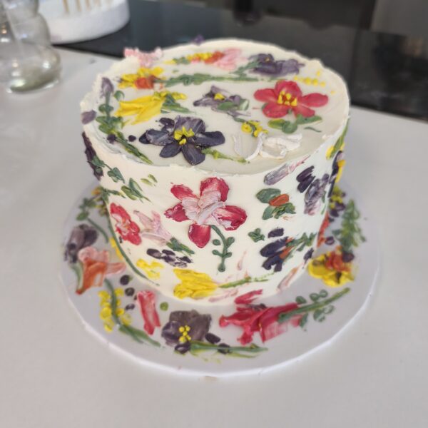 Bolo floral pintado à mão com buttercream colorido em tons vibrantes.