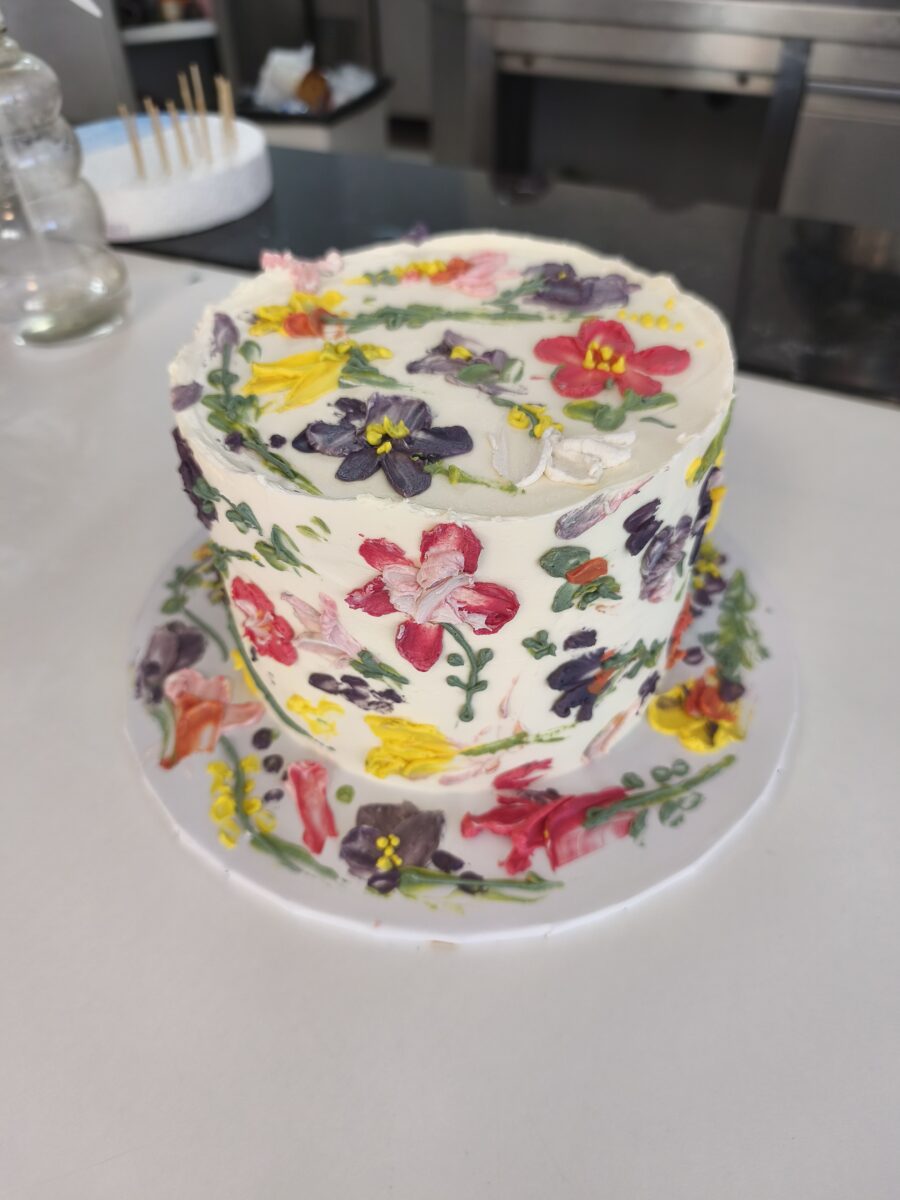 Bolo floral pintado à mão com buttercream colorido em tons vibrantes.