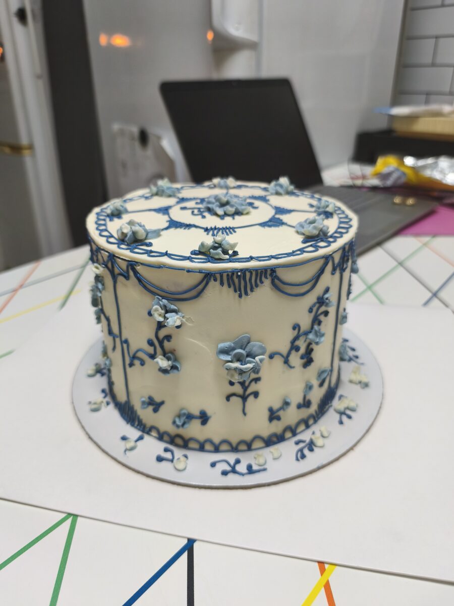 Bolo artesanal estilo porcelana azul com flores e arabescos em buttercream.