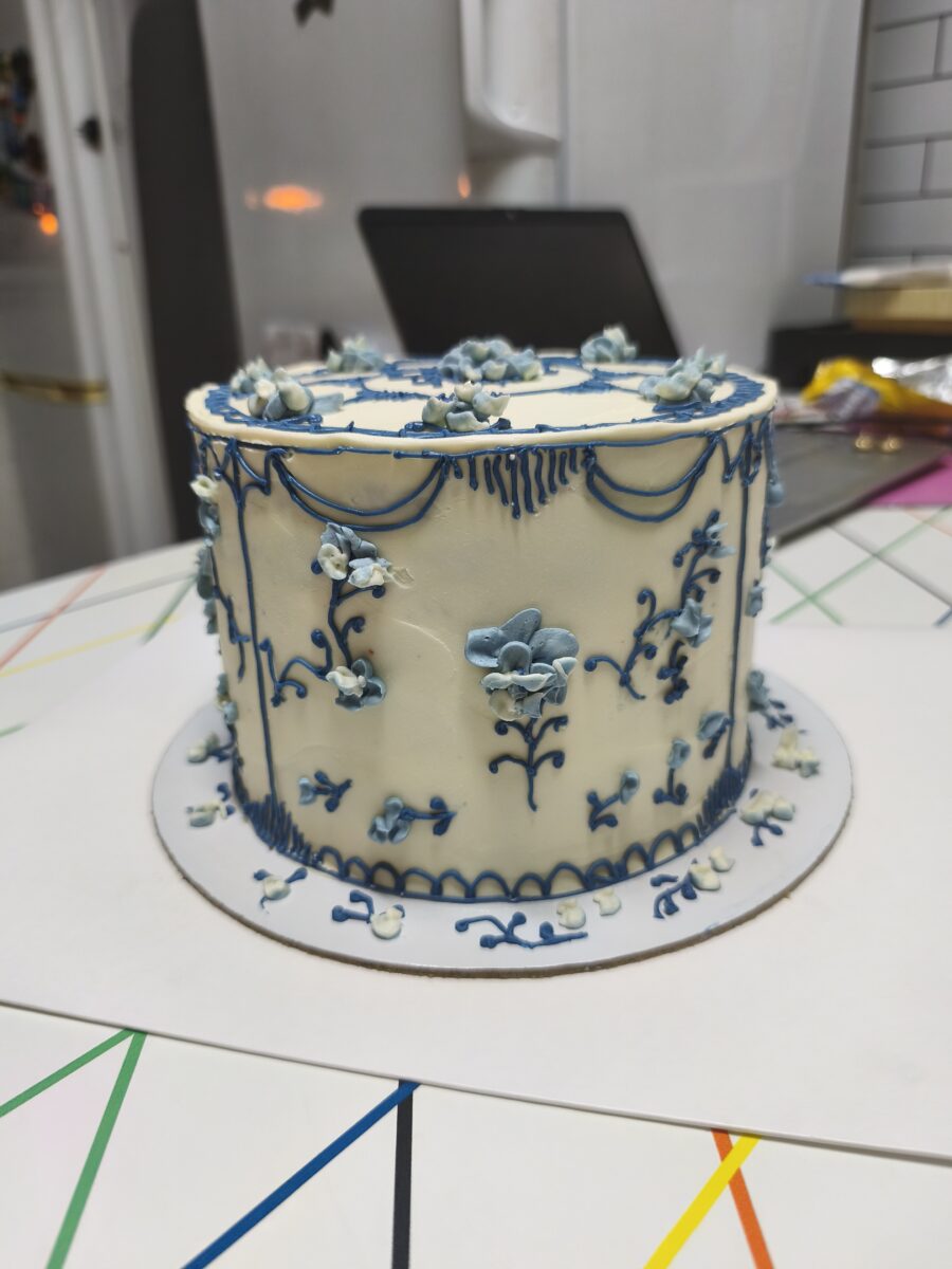 Bolo artesanal estilo porcelana azul com flores e arabescos em buttercream.