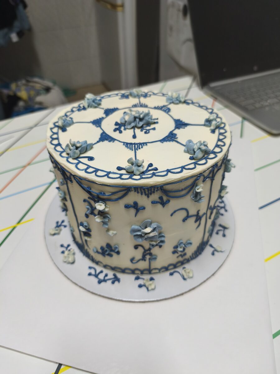 Bolo artesanal estilo porcelana azul com flores e arabescos em buttercream.