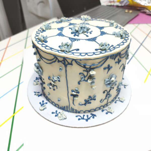 Bolo artesanal estilo porcelana azul com flores e arabescos em buttercream.