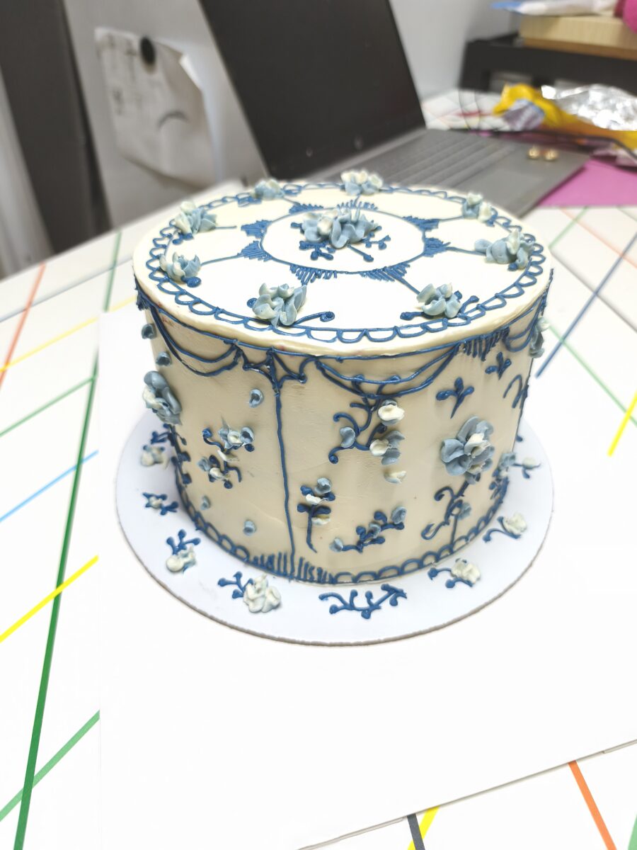 Bolo artesanal estilo porcelana azul com flores e arabescos em buttercream.