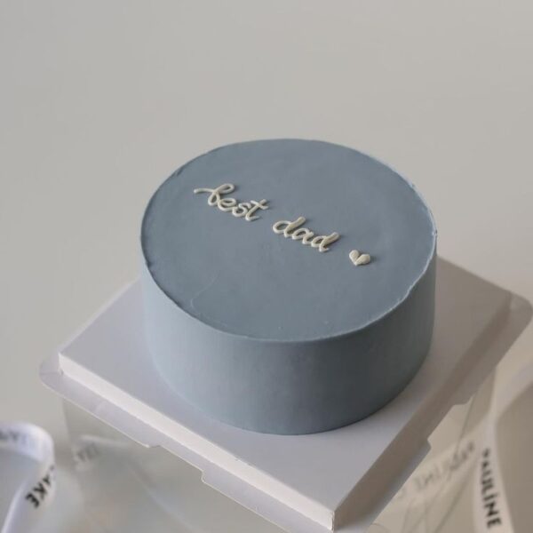 Mini bolo azul “Best Dad” com vela azul e design minimalista.