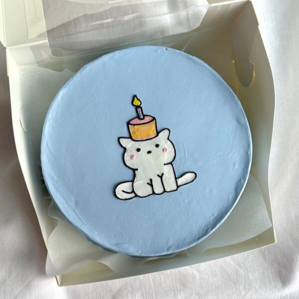 Mini bolo azul com gatinho e bolo de vela desenhado à mão.