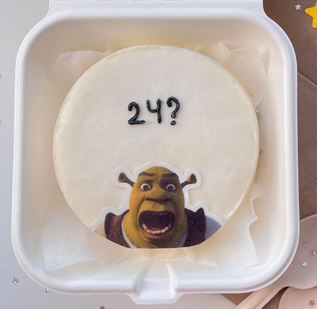 Bentô Cake Shrek – Mini Bolo Divertido Mini bolo branco com imagem do Shrek e número “24?”.